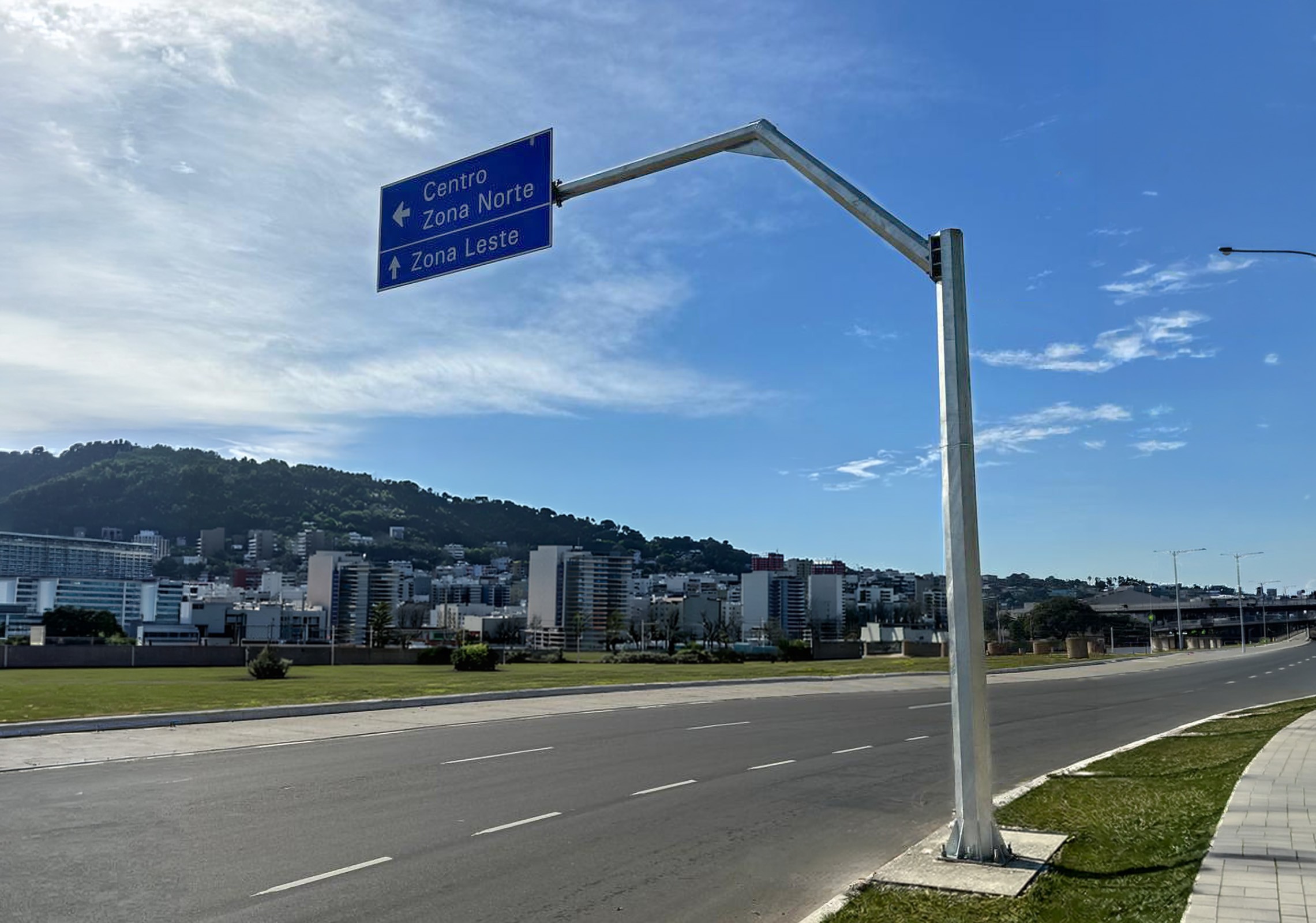 Semipórtico SP-300 para sinalização viária urbana, estrutura metálica galvanizada com placa direcional instalada em avenida.